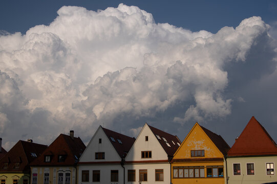 Aerial view of historic colorful houses with gabled roofs under massive dramatic white clouds in Bardejov, Presov Region, Slovakia.