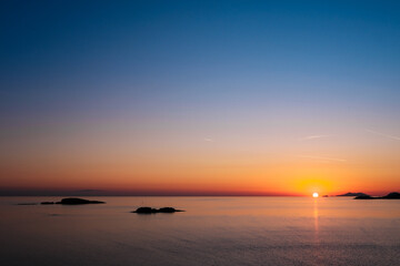 Fototapeta premium A stunning sunset casts a rich palette of colors across the Adriatic Sea, creating a serene atmosphere as day turns into night