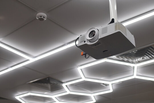 Front view of ceiling mounted digital projector in modern office or conference room