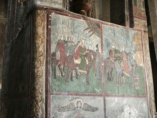 Ancient religious fresco depicting figures on horseback on a church wall. Historic medieval mural painting with king and riders in an orthodox cathedral © Elena