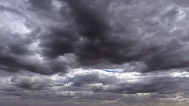 Dramatic view of heavy, dark storm clouds filling the sky over Brazil. The dense, gray clouds create a moody and powerful atmosphere, 