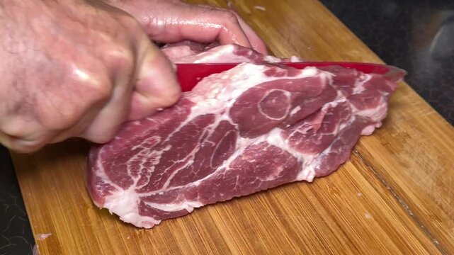chef cut meat on cutting board with sharp knife for making healthy meal and cooking, chef cutting raw meat into pieces, slicing for steak. Beef fillet langet, food closeup