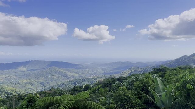 mountain valley, green hills, tropical forest, blue sky, white clouds, wide landscape, scenic view, forest canopy, distant mountains, lush vegetation, mountain range, tropical scenery, valley view, cl