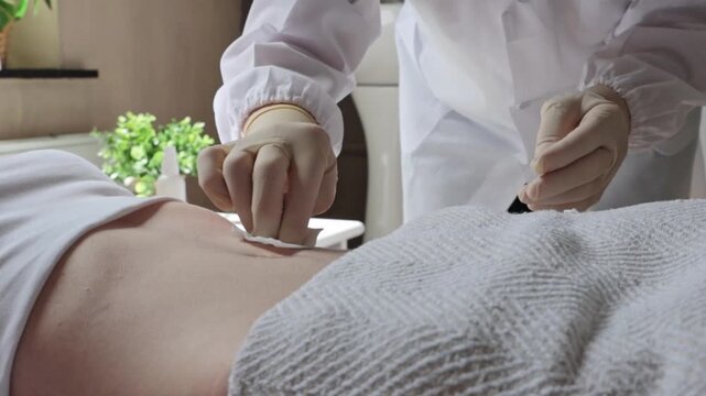 A nurse cleans a patient's abdomen for a colostomy bag.
