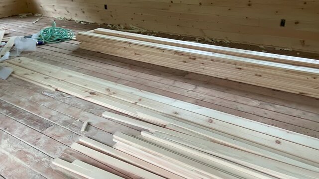 Stacked raw timber planks inside wooden gazebo construction.