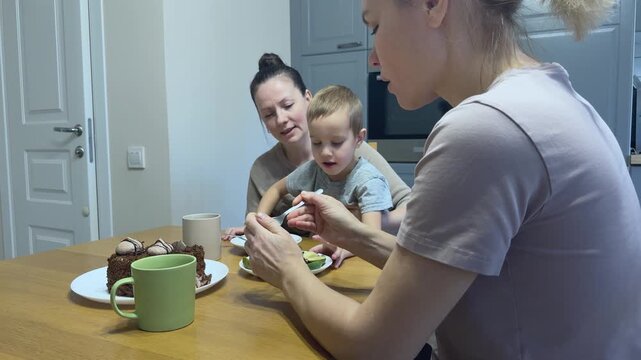 Child smiles while woman prepares feijoa fruit for him gentle family interaction and feeding care.