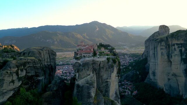 Epic Aerial Drone Monastery of Holy Trinity Sunset in Meteora, Greece. Fly Counter-Clockwise Church on Narrow Mountain Rock Incredible Landscape