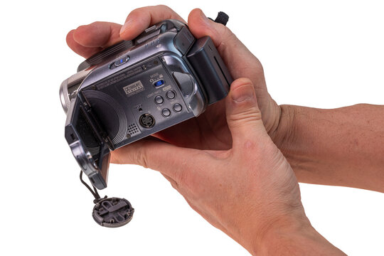 Close-up view of male hands holding JVC digital camcorder isolated on white background. Sweden. 