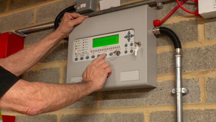 Fire alarm engineer investigating a fault on a fire protection system during planned maintenance, ensuring the safe and reliable operation of industrial fire suppression equipment. © RCH Photographic