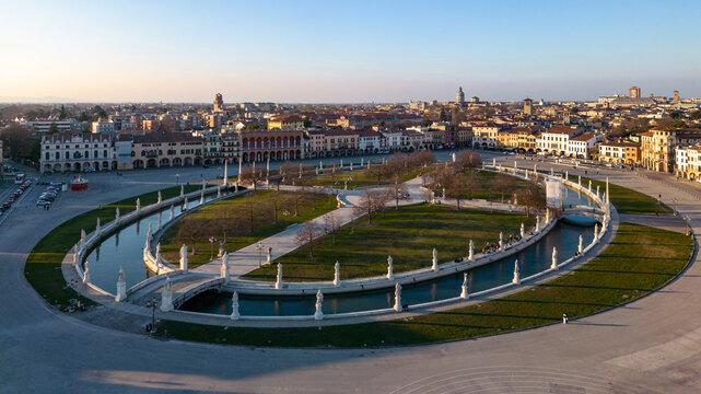 Aerial view of Prato della Valle featuring the elliptical canal and statues surrounded by historic architecture in Padova, Veneto, Italy.