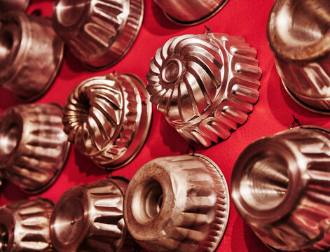 vintage aluminum molds used for making individual desserts like Bundt cakes or gelatin molds, commonly used for rustic kitchen wall decor