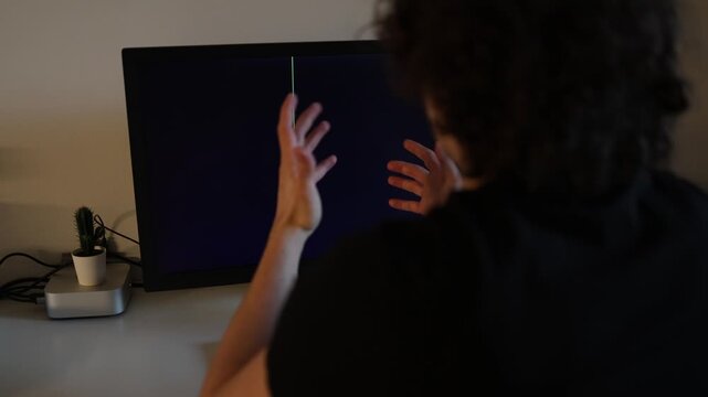 Curly young man looking confused because of damaged computer monitor black display with colorful vertical line modern workspace technology malfunction realistic office lifestyle scene