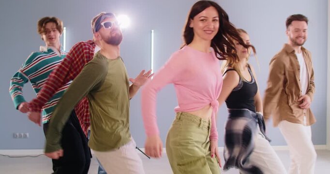 Active modern dance group discotheque friends disco class joy, fitness studio students and energetic dancing teacher learning contemporary movement together modern sporty event style in gym room