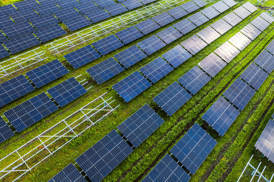 Aerial view of the FVE Bohumilice solar power plant with rows of photovoltaic panels and metal frames on green grass in Klobouky u Brna, Jihomoravsky kraj, Czechia.