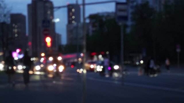 Blurry urban intersection at night with cars and traffic lights