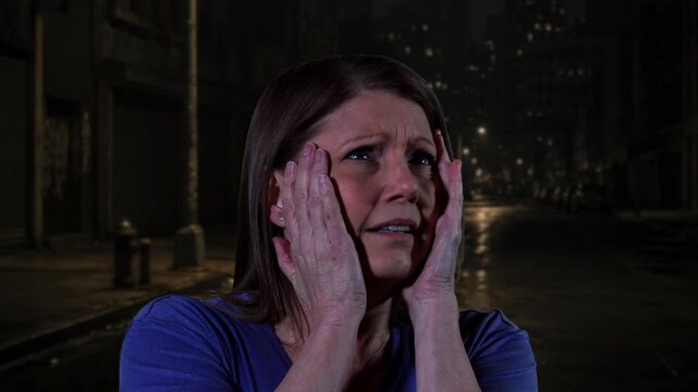 Frightened woman on a dark street at night