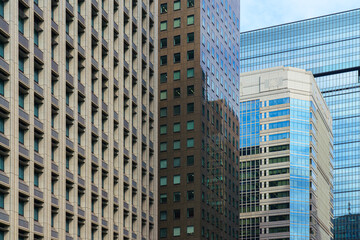 Fototapeta premium Tokyo, Japan - Oct 1 2024, A panoramic view of the glass facades of skyscrapers in Chiyoda district, with a blue sky and clouds in the background, at daytime,Tokyo, Japan