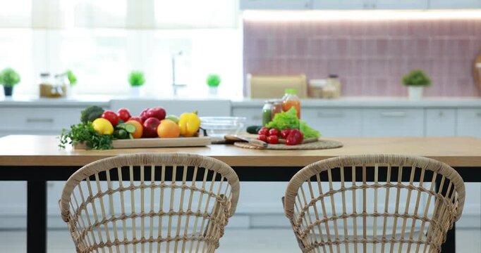 Fresh vegetables, fruits and drinks on wooden table in kitchen, camera moving in