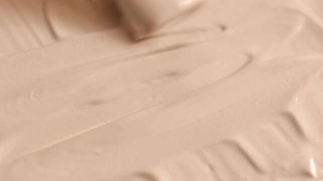 Woman smearing natural clay paste for facial and body care with makeup brush, closeup. Mud therapy