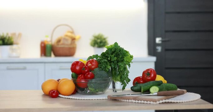 Fresh vegetables and fruits on wooden table in kitchen, camera moving in