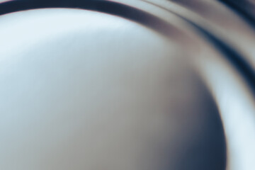 Silver metallic surface featuring a smooth texture with subtle circular grooves and shiny reflections. Industrial background