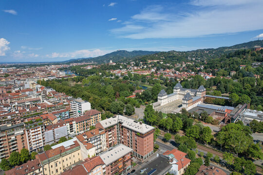 Aerial view of Castello del Valentino surrounded by lush greenery and the Po river under a clear blue sky in Torino, Piemonte, Italy.