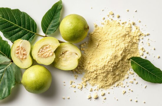 Yellow guava fruit with green leaves and powdered guava extract on white surface
