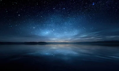 Fototapete Reflection Nighttime stars reflected on still water under dark blue sky  © TheoTheWizard
