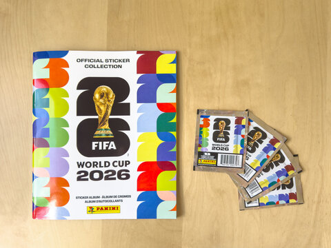 Calgary, Alberta, Canada. May 14, 2026. Official Panini FIFA World Cup 2026 sticker album and sealed packets on a wooden desk.