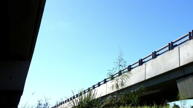 Light aircraft flying low over motorway overpass viewed from underneath bridge dramatic aviation perspective