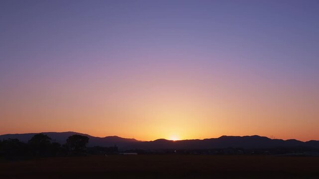 【タイムラプス】山並みの向こうに沈む夕日とドラマチックに変化するマジックアワーの空（福岡県小郡市）