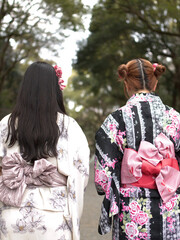 Obraz premium Two Japanese Women in Traditional Kimonos Walking Through a Forest Path