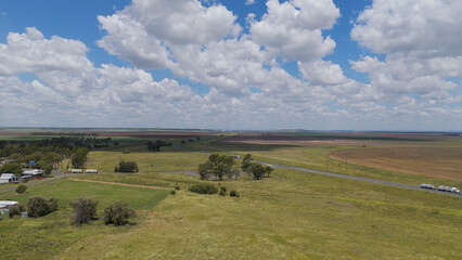 Fototapeta premium Aerial View of Rural Farmland with Highway and Fluffy Clouds