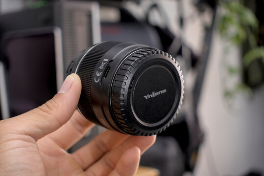 Zapopan Jalisco, Mexico - May 14, 2025: Hand holding Yongnuo 50mm f1.8 lens, yn camera lens concept
