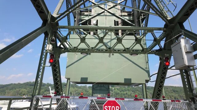 Gimbal close booming down shot of a riverboat passing through the raised lift bridge on the St. Croix River in Stillwater, Minnesota. 4K