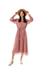 Fototapeta premium Beautiful young woman in stylish pink dress and hat on white background