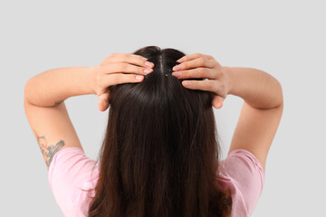 Naklejka premium Young woman with dandruff on light background, back view