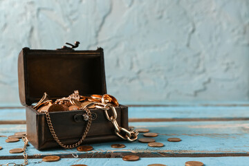 Old chest with treasures on blue wooden table near grunge wall © Pixel-Shot
