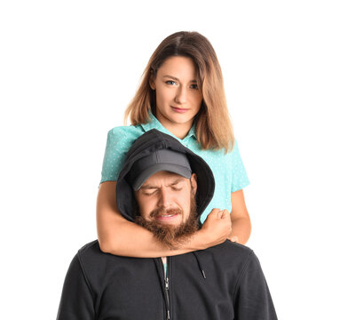 Young woman defending herself against robber on white background