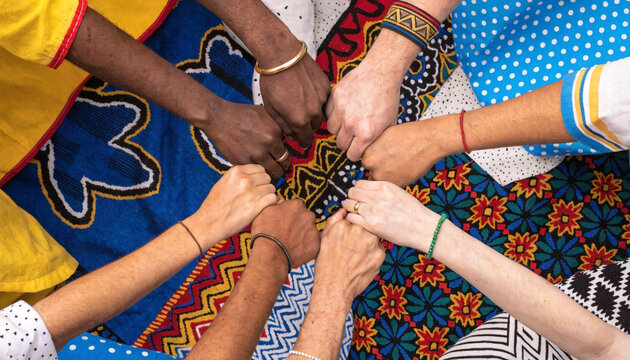 Diverse hands clasped together in unity and solidarity showing support and friendship among people of different ethnic backgrounds