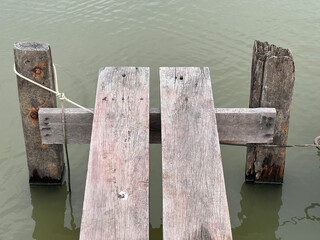 Obraz premium a vertical shot of a wooden pier with a fishing boat in the lake
