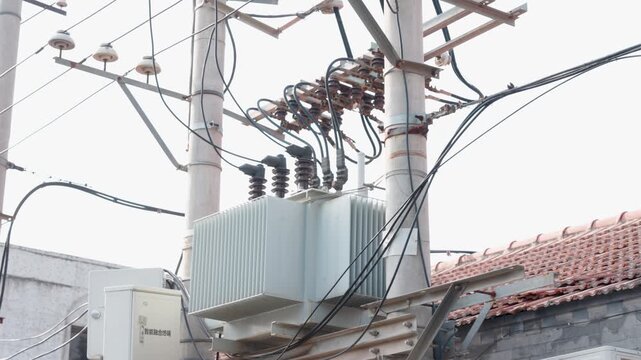 Close-up of an electrical distribution transformer mounted on utility poles in Beijing, China, showing power infrastructure, cables, and an urban energy system. UHD.