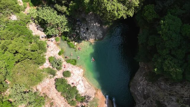 Aerial View of People Swimming in Natural Waterfall Pool at Polylimnio Canyon, Greece, Summer Travel Landscape