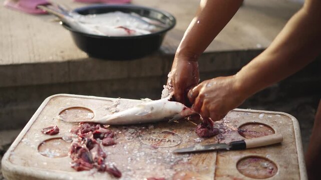 Fish Vendor Removing Fish Guts and Gills from Fresh Fish at Street Market