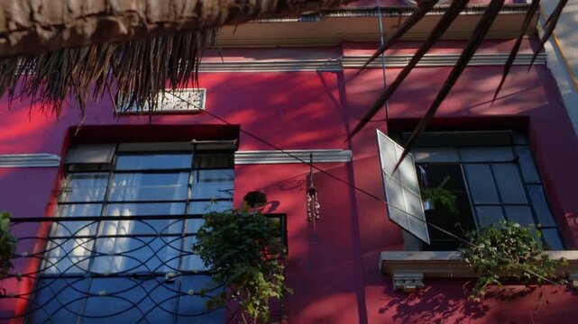 Fachada de casa roja en el atardecer, casa vieja con ventana negra