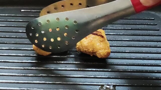 Footage of chicken being grilled on a teflon pan with delicious homemade cooking atmosphere.