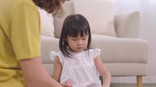 mother, daughter, family, Asian little girl touching ear with curious thinking expression at home, childhood learning moment, emotional quotient development, parenting lifestyle, cognitive behavior
