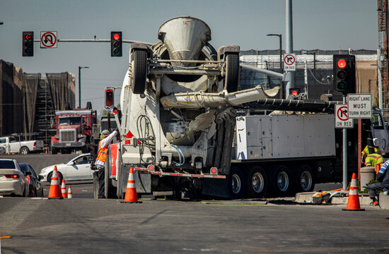 A construction worker near a cement mixer truck at a road intersection