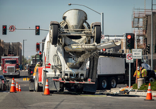 A construction worker near a cement mixer truck at a road intersection
