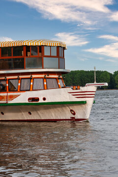 Danube River in Romania, Multi-Deck Tour Boat Navigating Calm Water Under a Partly Cloudy Sky